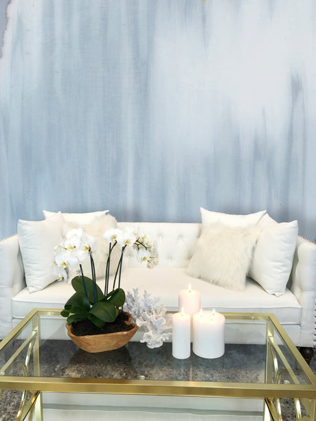 Vivian Ferne Grey Themed, Monochromatic wallpaper design, "Grey Wave" is full of fresh and calming blue tones, with misty grey textures. This wallpaper design is staged with a white sofa, gold and glass coffee table, orchids, and white candles. Famous wallpaper designer, Fran Maass was inspired by the way these colors could transform living room walls, accents walls and bedroom decor. This product is available in French Lux, Pre pasted and Peel & Stick materials.