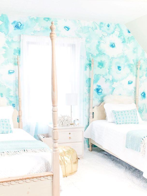 Kids bedroom interior decor with large pattern watercolor wallpaper. This bedroom decor features two four-post beds and stunning teal, turquoise wallpaper. This ocean themed design helps bring the textures of the ocean back into your home.