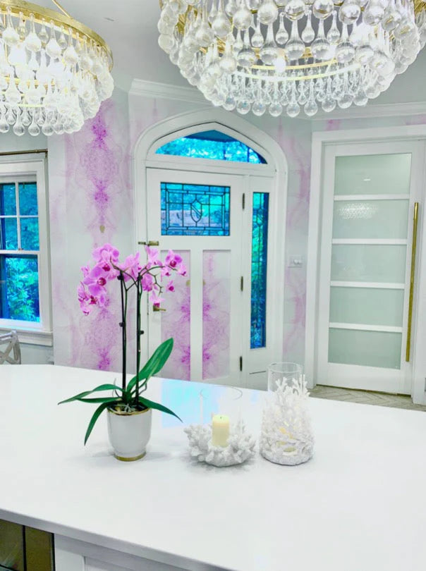 White themed kitchen with white counter tops, white trim and and splash of lilac color on the entry way wall using peel and stick wallpaper from Vivian Ferne.
