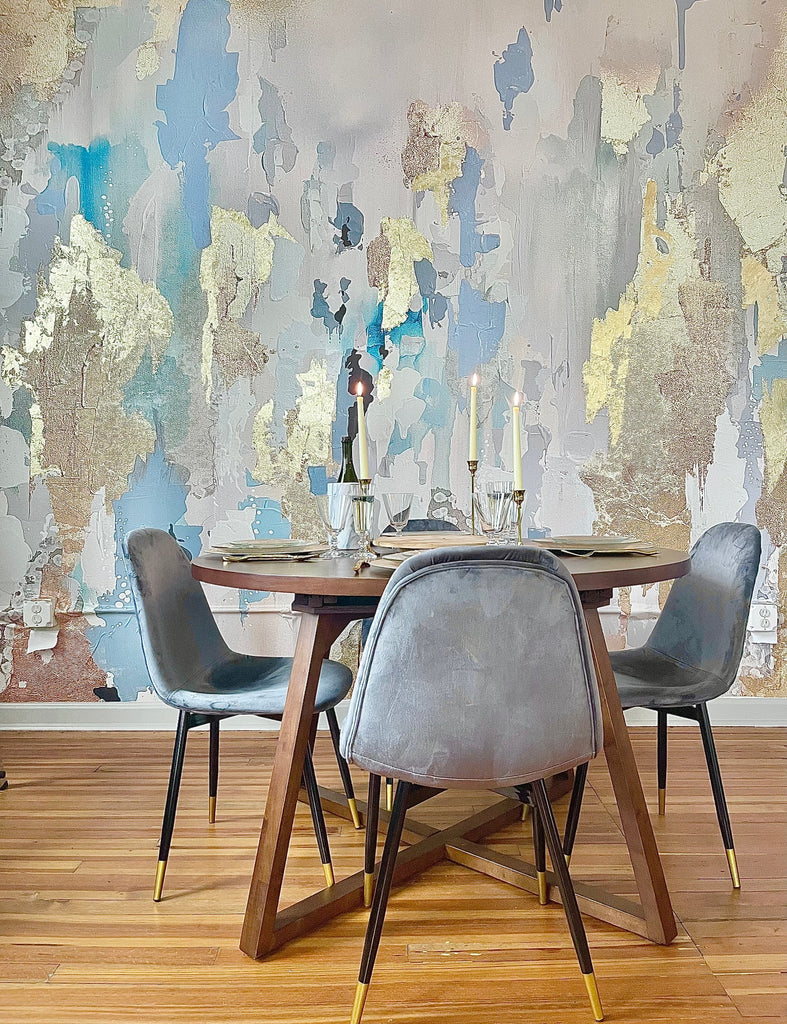 The blue and gold wallpaper is the center piece of this dining room decor. The minimal grey chairs and round wooden dining room table set the forefront of this stunning interior wallpaper design. The wallpaper features versatile blues, soft grays/pinks and golds. The shapes of this wallpaper are bold yet the colors are soft and inviting. This wallpaper design is a great addition to any living room decor, bedroom decor or salon.