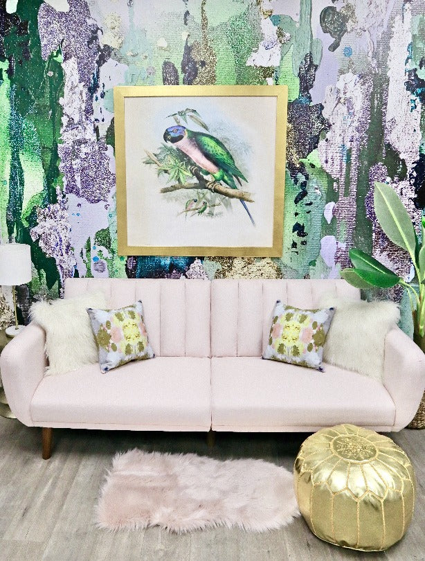 Transform your living room decor with a tropical themed wallpaper. This image shows the fully transformed look with pink sofa, gold pillows and botanicals. The wallpaper features rich greens and silvers that create a stunning centerpiece for your interior design project.