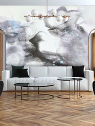 This image is a modern, minimal living interior design concept with a large scale abstract wallpaper installation from famous interior design shop, Vivian Ferne. This wallpaper design incorporates dusty smokey grays, blacks and faint purple tones. This design is a digital recreation of an original abstract painting from famous painter Frances Maass Katz.