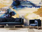 Blue and gold abstract accent wall. This abstract wallpaper design was inspired by the colors, tones and textures of the ocean. The mural sits behind luxury rustic blue suede furniture and black and gold coffee table. Distressed wood flooring allows the richly textured acrylic and alcohol ink design to shine through.