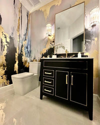 This all black and gold powder room design features a stunning large scale abstract wallpaper mural design from famous wallpaper shop, Vivian Ferne. Rich gold tones, inky black shapes and misty blush tones create a stunning bathroom design.