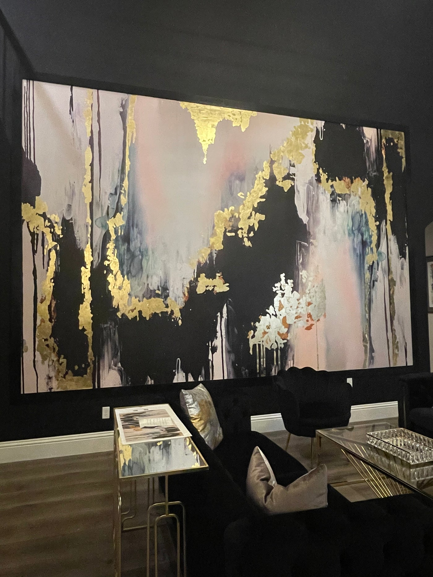 Abstract wall mural called "Speakeasy" with gold accents and black frame on a black wall.