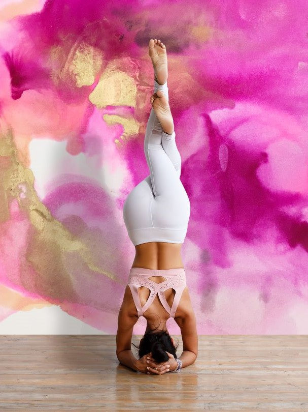 Yoga pose in front of a pink and orange wall mural
