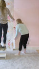 This large pattern wallpaper design created a stunning backdrop for this nursery interior design project. The large pattern wallpaper mural features, pinks, mints, beiges and gold tones to create striking shapes and textures on the nursery wall.