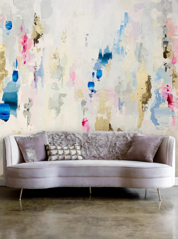 This beached themed interior design installation features, marine blues, peaches and beiges on the wallpaper and a concrete polished floor design. The couch in this staging is a  Chesterfield style.