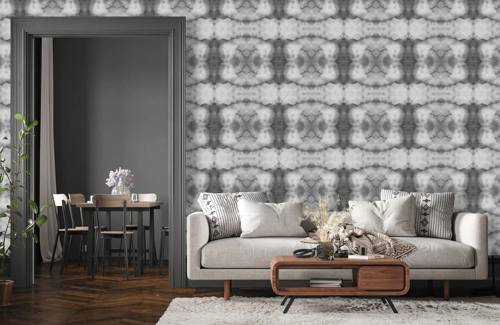 The interior wallpaper design, Gray Cloud is shown in this staging. The repeating pattern is a stunning monochromatic interior design that will complete any concept for living room decor, dining room decor or bedroom. The gray tones and textures look great with dark or light woodwork. This image also features modern, rounded furniture potted plans and gray baseboards.