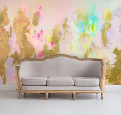 This luxury interior design installation features lilac, peach and teal abstract wallpaper that is inspired from the original abstract painting from famous designer, Frances Maass. The living room features a beige and wood cabriole classic couch and white hardwood floors.