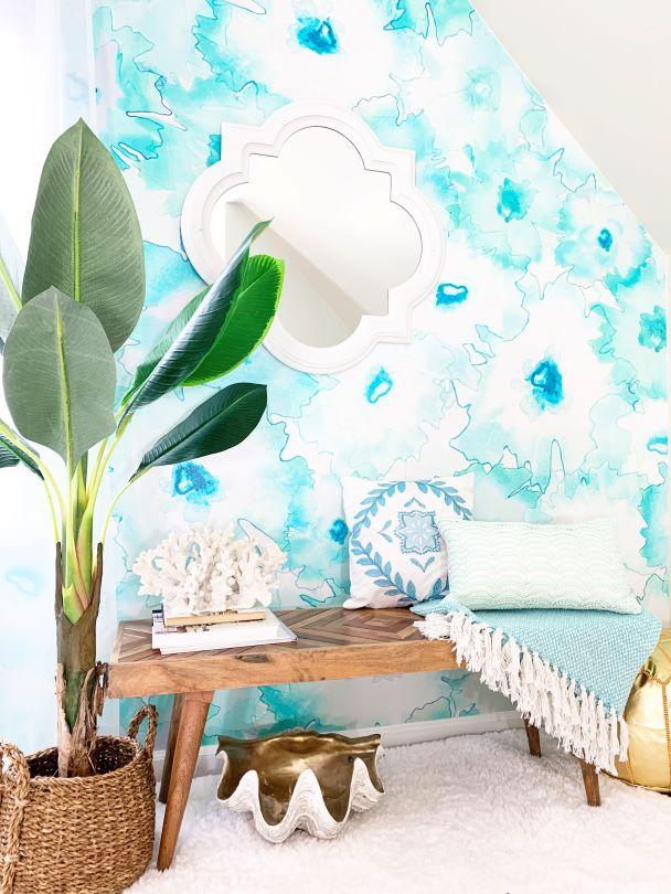 This large pattern wallpaper design in an entry features large watercolor shapes. The turquoise and teal tones and watercolor textures create a calming, vibrant piece of wall decor.