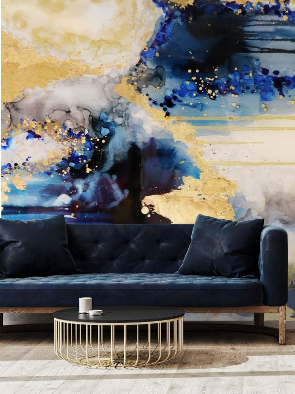 Abstract blue and gold wallpaper wall mural behind blue velvet sofa
