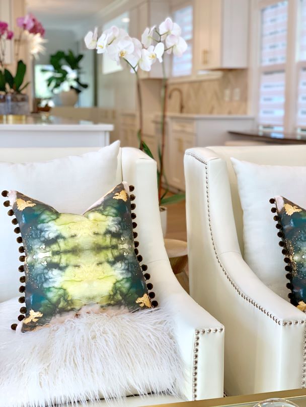 green jade pom pom textured pillow on a white fur chair