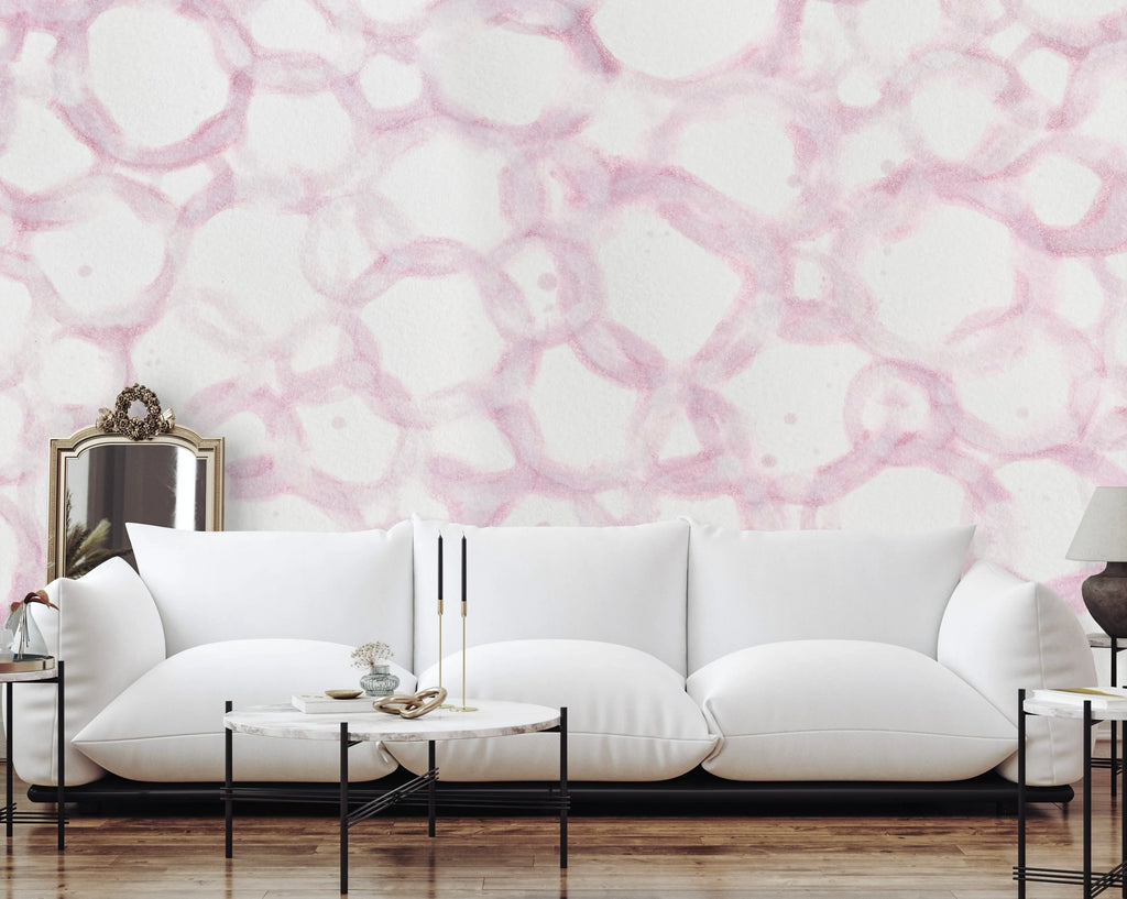 This living room interior design staging ultra modern, minimal coffee tables and floor level puffy white couch. The walls are decorated with a pink themed, large pattern wallpaper.  This wall decor can be achieved using prepasted, peel and stick or French Luxe wallpaper.