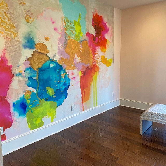 Living room decor gets taken to the next level with this stunning peel and stick wallpaper installation. Featuring rich pinks, blues, greens and golds this abstract wallpaper design is sure to be a talking point for anyone  interested in luxury wall decor.