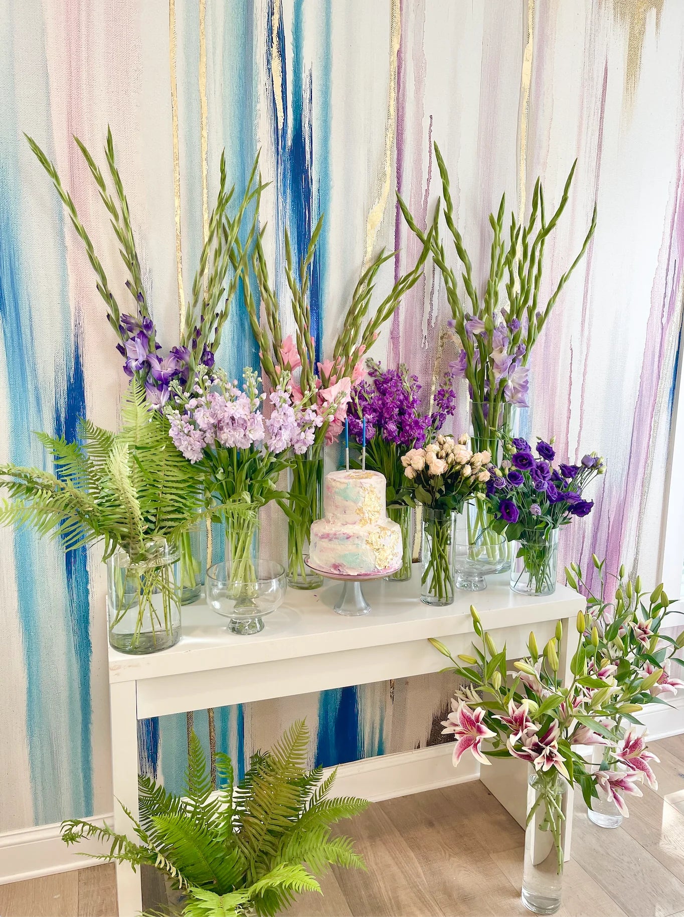 This interior design staging showcases a stunning abstract wallpaper installation with a large arrangement of flower and plants. The luxury abstract wall art is digitally recreated from an original painting from famous abstract artist, Fran Maass Katz.