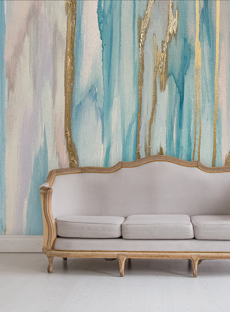 This close up living room decor was inspired by a classing camel back couch, light wood floors and this stunning large scale wallpaper mural. The wallpaper design features cool aquas, light lavenders and pinks and gold leafing. 