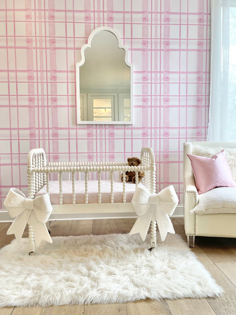 This pink themed nursery is a modern take on the classic plaid design. The simple decor allows for the peel and stick wallpaper to pop and create a calming happy interior design space for any child.